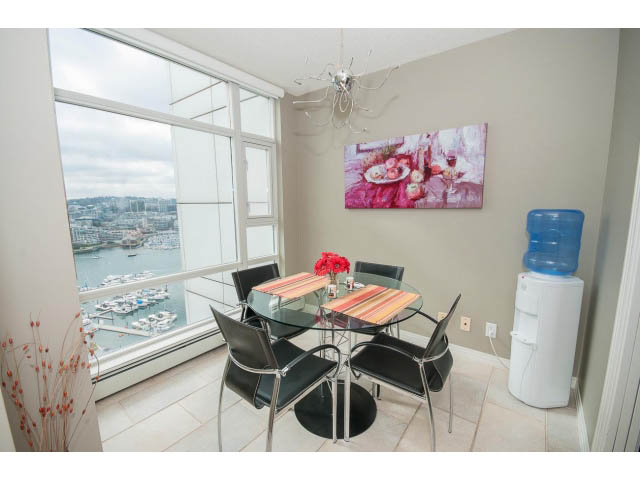 Bright dining area with city view, modern decor, and a waterfront panorama. - 2706 -198 Aquarius Mews, Vancouver Downtown