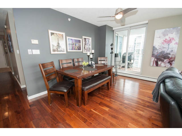 Furnished dining area with hardwood floors and city view through sliding glass doors. - 2706 -198 Aquarius Mews, Vancouver Downtown