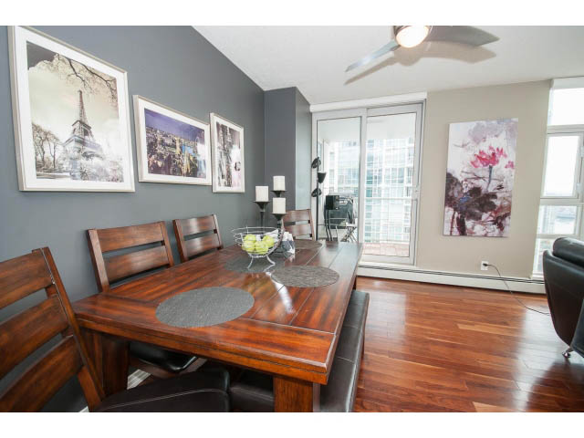Furnished dining area with hardwood floors, modern artwork, and city view. - 2706 -198 Aquarius Mews, Vancouver Downtown