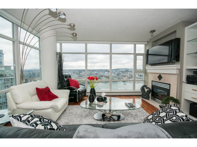 Bright living room with city view, modern furnishings, and hardwood floors. - 2706 -198 Aquarius Mews, Vancouver Downtown