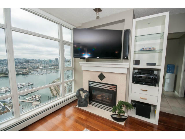 Bright living room with hardwood floors, city view, and modern entertainment setup. - 2706 -198 Aquarius Mews, Vancouver Downtown