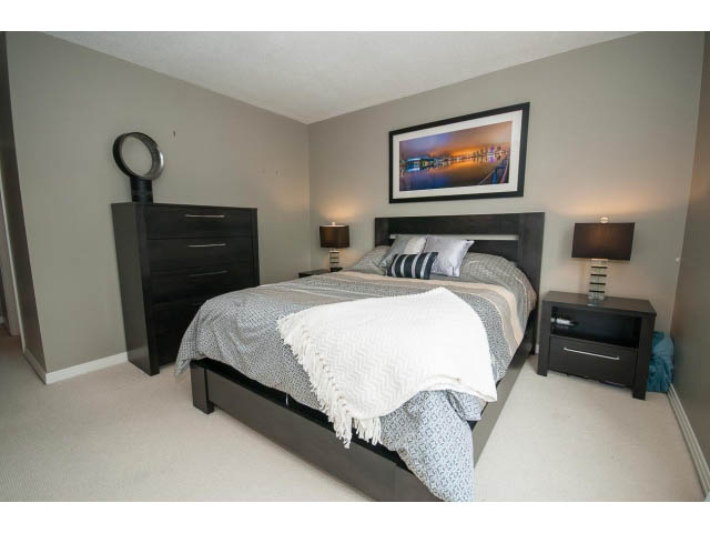 Furnished 2-bedroom + den with modern decor, dark wood furniture, and a framed art piece above the bed. - 2706 -198 Aquarius Mews, Vancouver Downtown