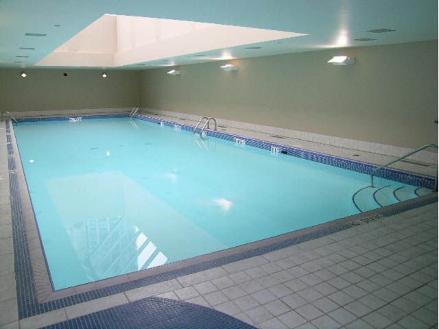 Spacious, well-lit indoor pool with tiled edges and ceiling lights. - 2706 -198 Aquarius Mews, Vancouver Downtown