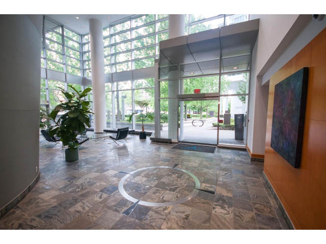 Spacious living room with large windows, modern decor, and a view of the city. - 2706 -198 Aquarius Mews, Vancouver Downtown
