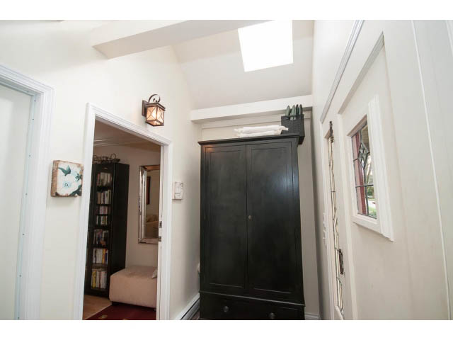 Bright entryway with dark wooden cabinet and skylight, leading to a cozy den area. - 3 - 2535 West 6th Ave, Vancouver West Side