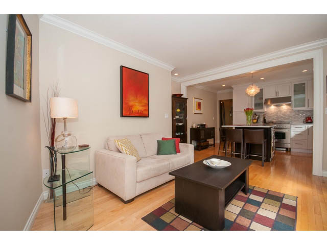 Bright living room with hardwood floors, modern decor, and open kitchen in the background. - 3 - 2535 West 6th Ave, Vancouver West Side