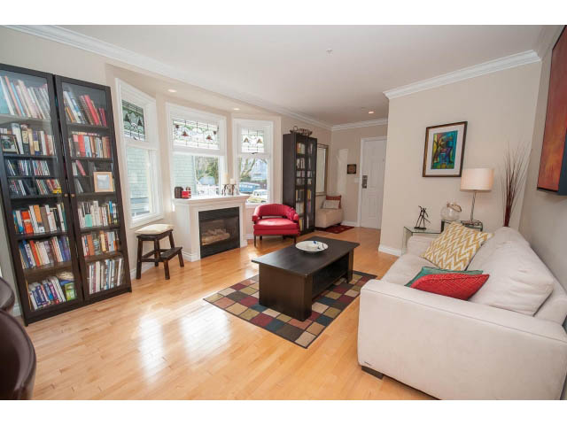 Spacious living room with hardwood floors, large windows, and a cozy sofa. - 3 - 2535 West 6th Ave, Vancouver West Side