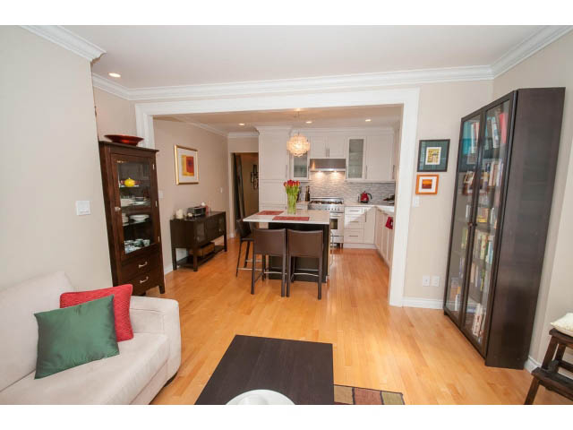 Open-concept living room and kitchen with hardwood floors and modern decor. - 3 - 2535 West 6th Ave, Vancouver West Side