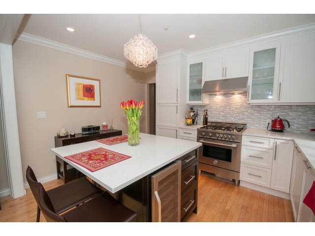 Bright kitchen with white cabinets, granite countertops, and hardwood floors. - 3 - 2535 West 6th Ave, Vancouver West Side