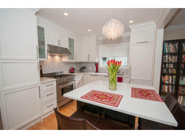 Bright kitchen with white cabinetry, granite countertops, and hardwood floors. - 3 - 2535 West 6th Ave, Vancouver West Side