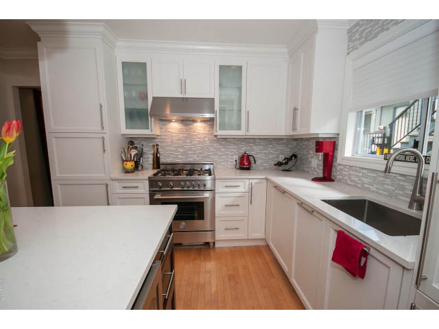 Bright kitchen with white cabinets, granite countertops, and hardwood floors. - 3 - 2535 West 6th Ave, Vancouver West Side