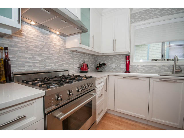 Bright kitchen with white cabinets, granite countertops, and a gas stove. - 3 - 2535 West 6th Ave, Vancouver West Side