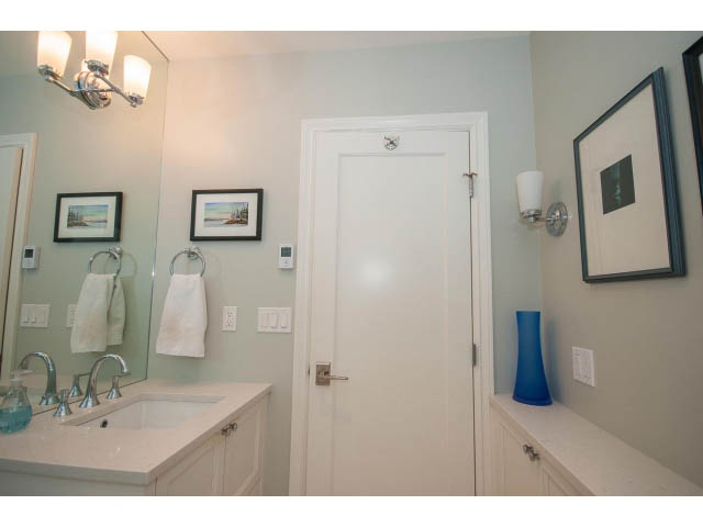Bright bathroom with white cabinetry, modern sink, and framed artwork. - 3 - 2535 West 6th Ave, Vancouver West Side