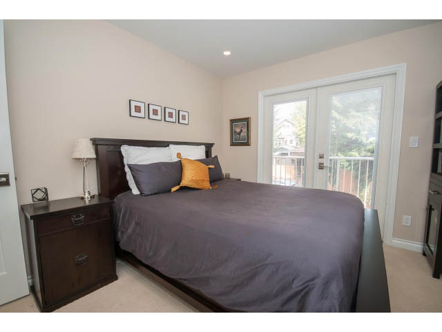 Spacious bedroom with a large bed, wooden headboard, and a sliding glass door leading to a balcony. - 3 - 2535 West 6th Ave, Vancouver West Side