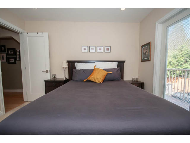 Furnished bedroom with dark wood headboard, gray bedding, and a view of the balcony. - 3 - 2535 West 6th Ave, Vancouver West Side