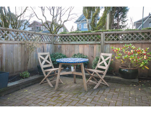 Furnished patio with wooden furniture and lattice fence, surrounded by trees. - 3 - 2535 West 6th Ave, Vancouver West Side