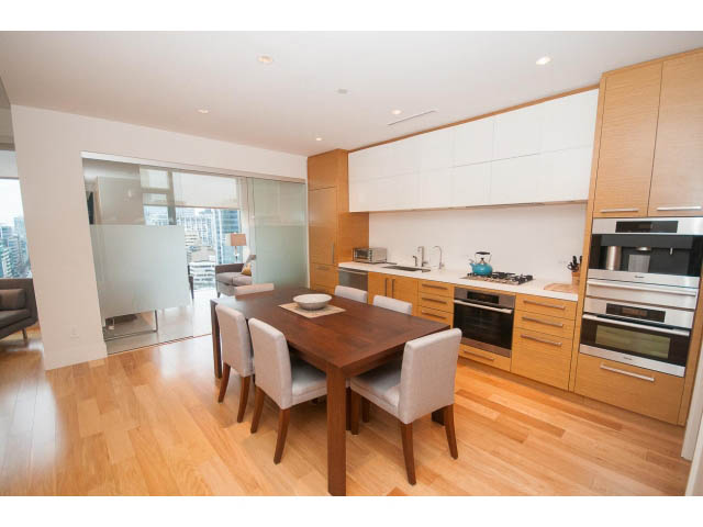 Bright kitchen with modern white cabinetry, hardwood floors, and city view. - 1701 - 667 Howe Street, Vancouver Downtown