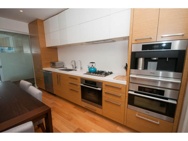 Bright kitchen with modern appliances, hardwood floors, and a city view. - 1701 - 667 Howe Street, Vancouver Downtown