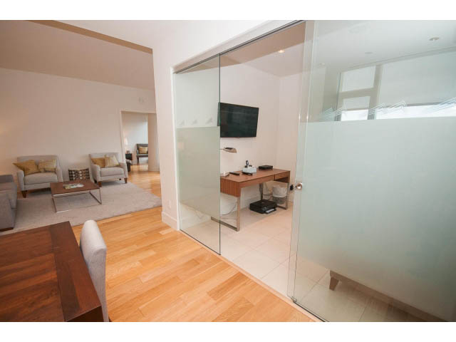 Spacious living area with hardwood floors, modern furnishings, and a sliding glass door leading to a private balcony.