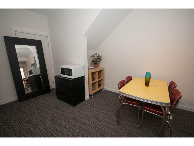 Furnished living room with yellow countertops and red chairs. - Suite - 1252 Duncan St, West Vancouver