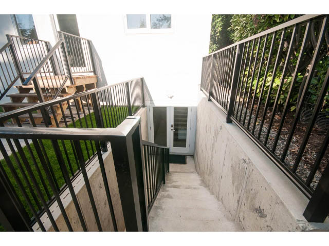 Staircase leading to upper level with black railings and concrete steps. - Suite - 1252 Duncan St, West Vancouver