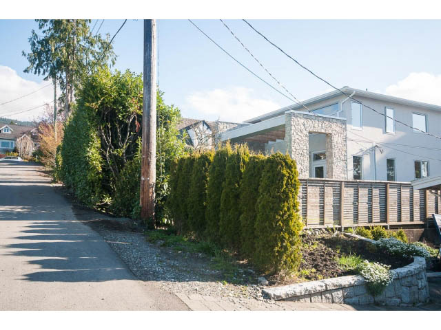 Furnished 2-bedroom suite with modern design, stone accents, and lush greenery. - Suite - 1252 Duncan St, West Vancouver