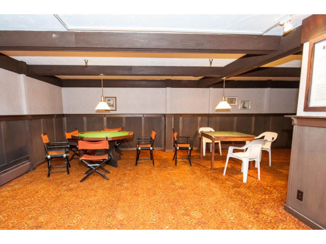 Furnished dining area with orange chairs and patterned carpet. - 606 - 2020 Fullerton Ave, North Vancouver