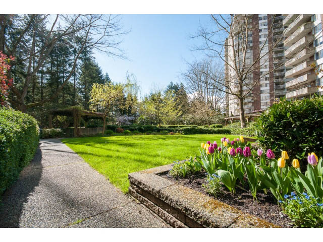 Furnished living room with cozy fireplace and large windows. - 606 - 2020 Fullerton Ave, North Vancouver