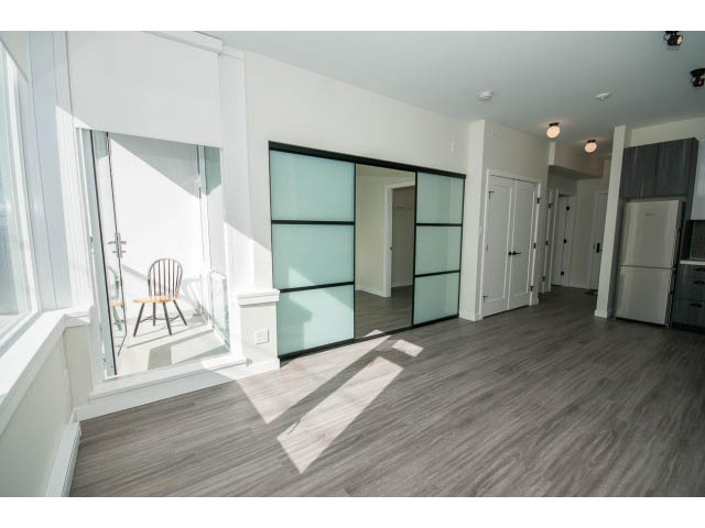 Bright kitchen with hardwood floors and glass sliding doors leading to a balcony. - 317 - 311 East 6th Avenue, Vancouver East Side