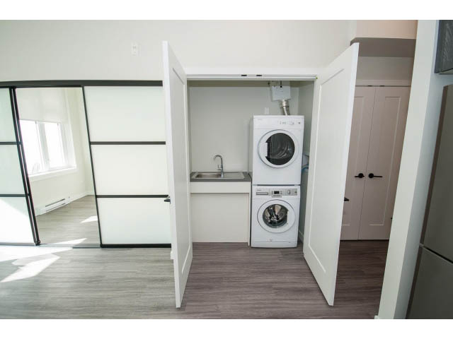 Bright laundry room with white cabinets, countertop, and hardwood floors. - 317 - 311 East 6th Avenue, Vancouver East Side