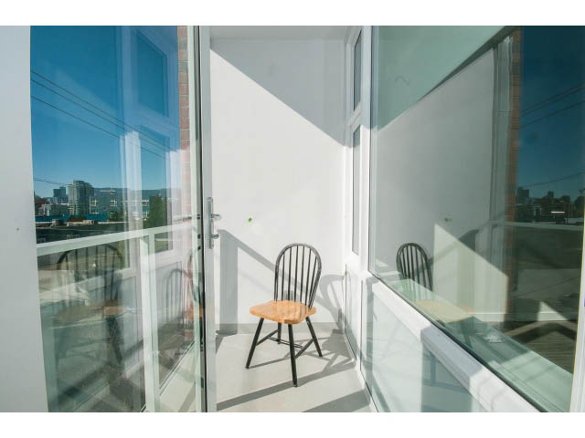 Bright balcony with city view and modern chair. - 317 - 311 East 6th Avenue, Vancouver East Side