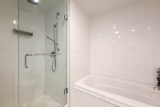 Bathroom with white tile walls, a glass-enclosed walk-in shower, and a built-in bathtub. - 1904-788 Richards Street, Vancouver Downtown