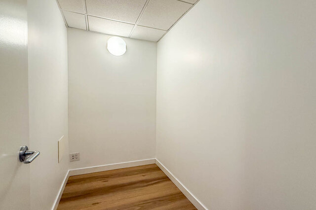 Compact den with hardwood floors, white walls, and a drop ceiling with a round flush light. - 1904-788 Richards Street, Vancouver Downtown