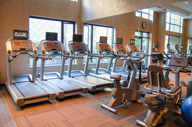 Fitness room with a row of treadmills, stationary bikes, and large windows over a wood-look floor. - 1904-788 Richards Street, Vancouver Downtown