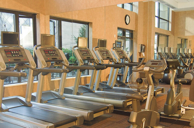 Fitness room with a row of treadmills, large windows, and a mirrored wall. - 1904-788 Richards Street, Vancouver Downtown