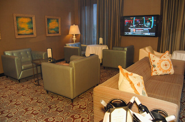 Furnished living room with leather armchairs, a striped sofa, wall-mounted TV, and patterned carpet. - 1904-788 Richards Street, Vancouver Downtown