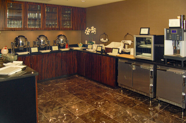 Breakfast bar with dark wood cabinetry, black countertops, and polished marble tile flooring. - 1904-788 Richards Street, Vancouver Downtown