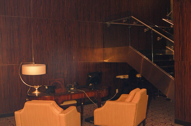 Cozy den with dark wood paneling, upholstered armchairs, and a glass-railed staircase. - 1904-788 Richards Street, Vancouver Downtown
