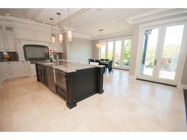 Bright kitchen with granite countertops and large windows, showcasing a serene outdoor view. - 3921 West 10th, Vancouver West Side