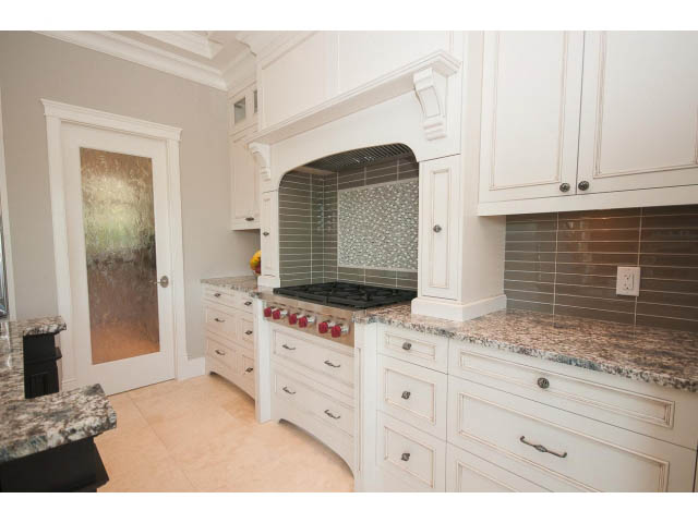 Bright kitchen with white cabinets, granite countertops, and a tiled backsplash. - 3921 West 10th, Vancouver West Side