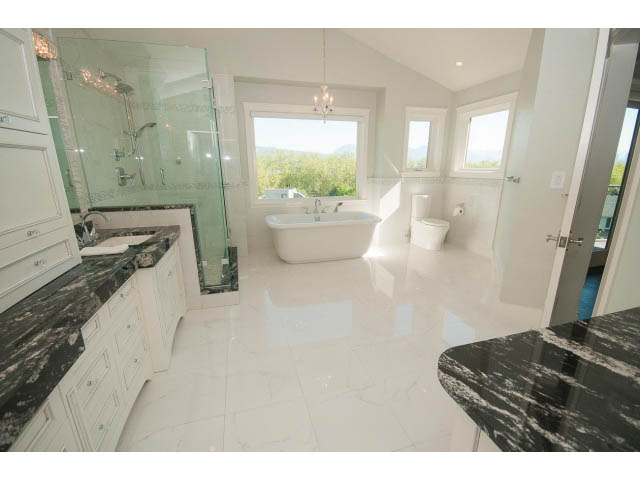 Spacious bathroom with marble countertops and a large window offering a scenic view. - 3921 West 10th, Vancouver West Side