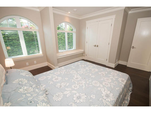 Furnished bedroom with floral bedding and arched windows. - 3921 West 10th, Vancouver West Side
