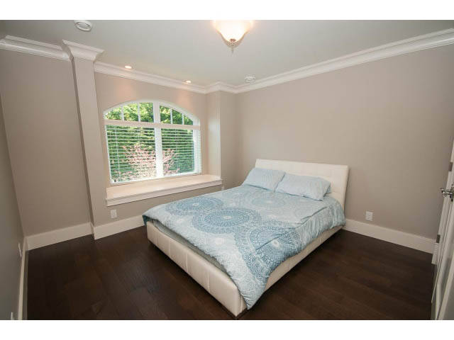Spacious bedroom with hardwood floors and a large arched window. - 3921 West 10th, Vancouver West Side