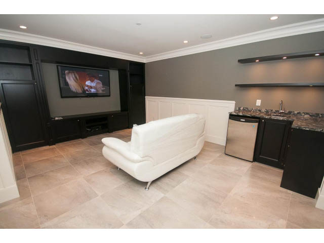 Living room with modern furniture, flat-screen TV, and granite countertops. - 3921 West 10th, Vancouver West Side