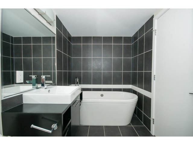 Furnished bathroom with black and white tiles, modern sink, and bathtub. - 3006 - 188 Keefer Place, Vancouver Downtown