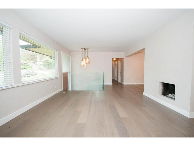 Open-concept living room with hardwood floors and a city view. - 3188 St. Andrews Ave, North Vancouver
