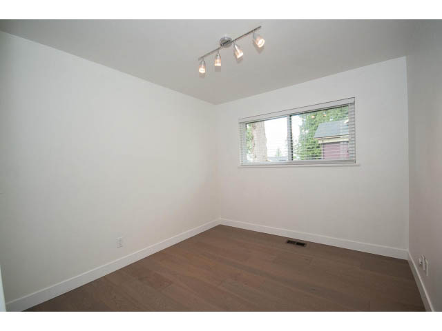Bright bedroom with hardwood floors and a window view. - 3188 St. Andrews Ave, North Vancouver