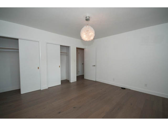 Bright living room with hardwood floors and a modern chandelier. - 3188 St. Andrews Ave, North Vancouver