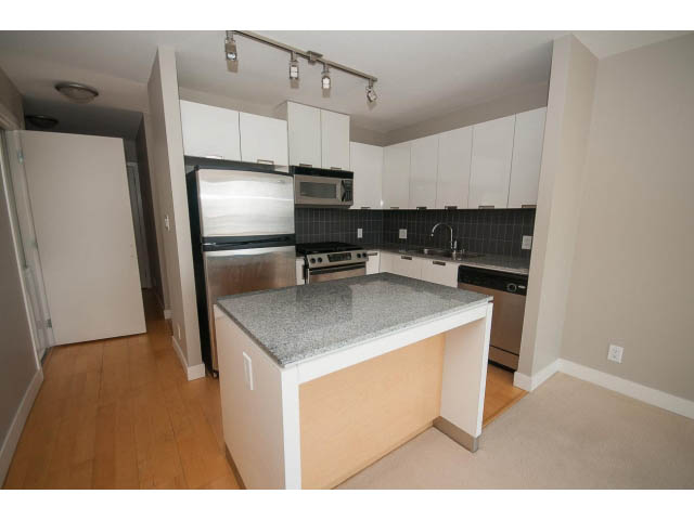 Bright kitchen with granite countertops, hardwood floors, and white cabinetry. - 701 - 151 West 2nd Street, North Vancouver
