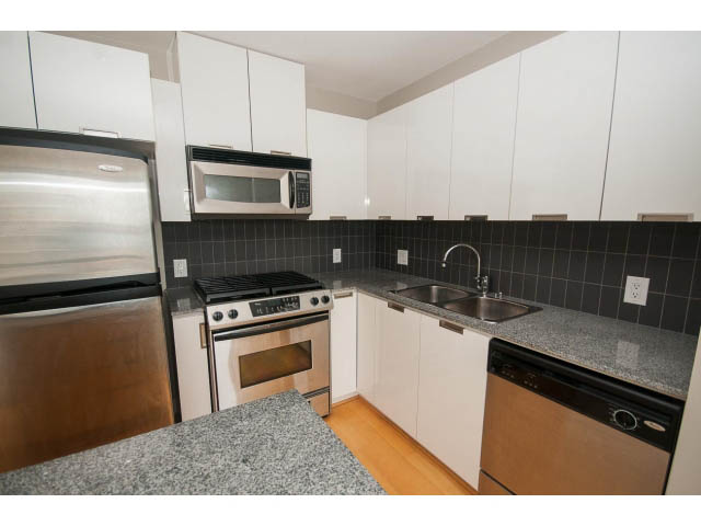 Bright kitchen with granite countertops, stainless steel appliances, and hardwood floors. - 701 - 151 West 2nd Street, North Vancouver